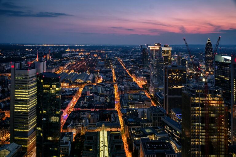 Aerial view of Frankfurt's modern skyline illuminated at dusk, showcasing the vibrant urban landscape.